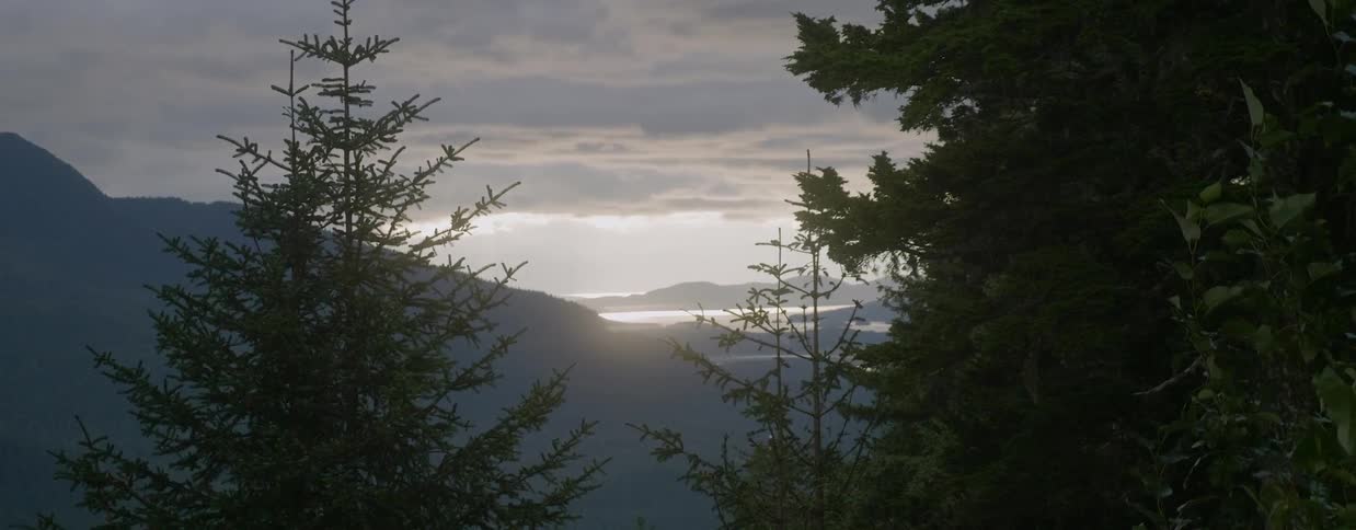 Sun setting behind mountains on a cloudy evening