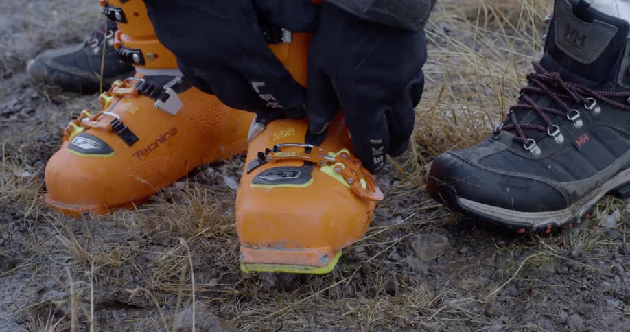 A skier fastens their ski boots