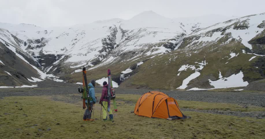 Mountaineers planning their route with all their gear next to their tent