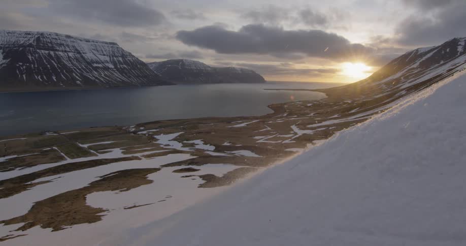 Skiing down the side of a mountain at sunset