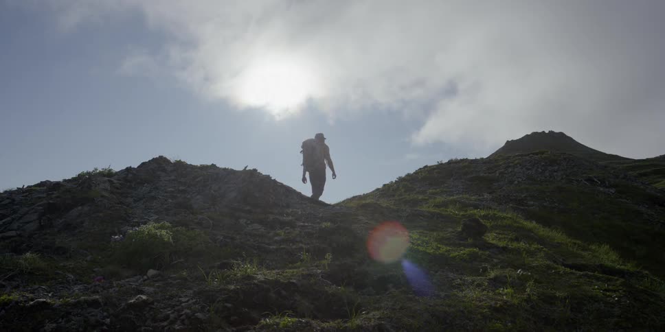 Man hikes up a hilltop