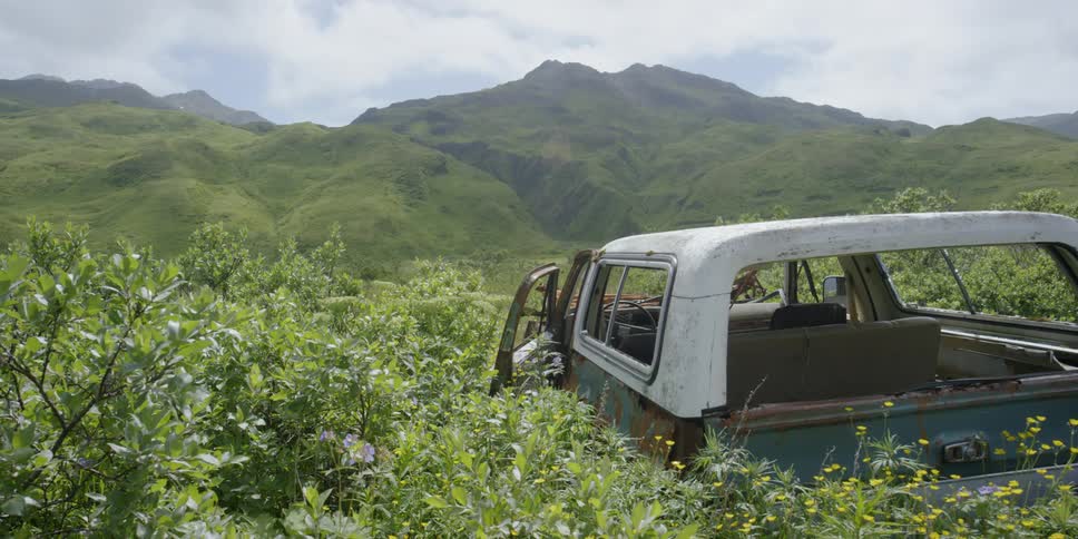 Rusted out suv on a grassy mountain