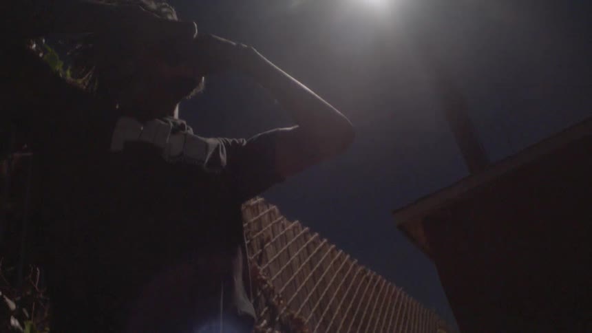 A man is dancing at night under a street lamp