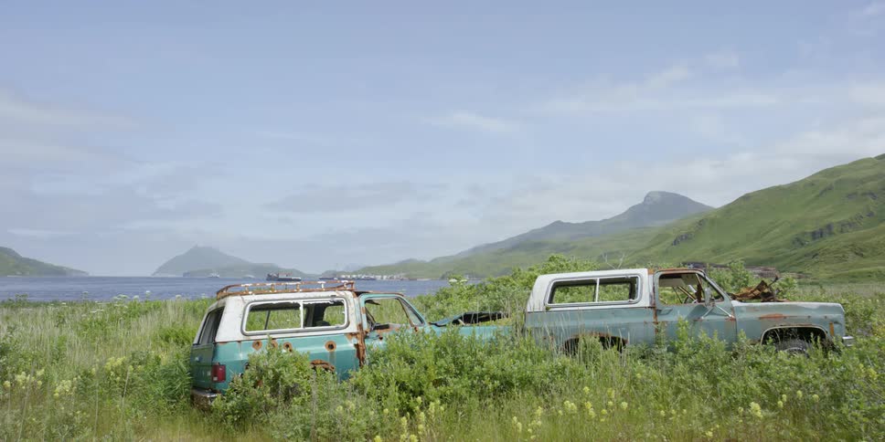 Two rusty vehicles in a field