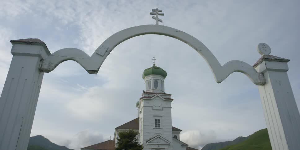 An archway of a church is with the steeple of the church in the background
