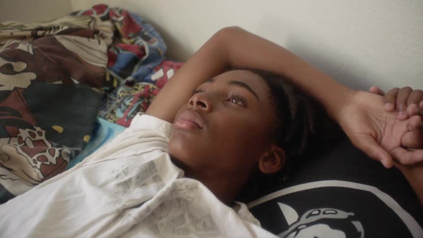 Someone is lying in bed looking up at the ceiling