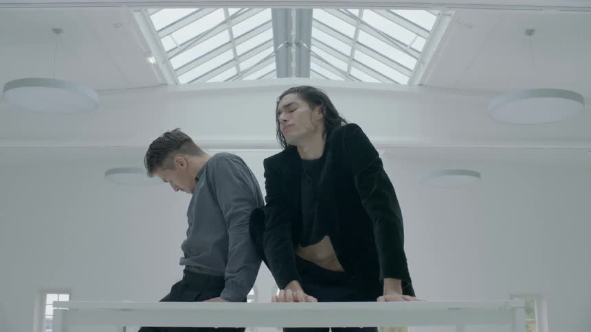 Man and woman dance together in a white room