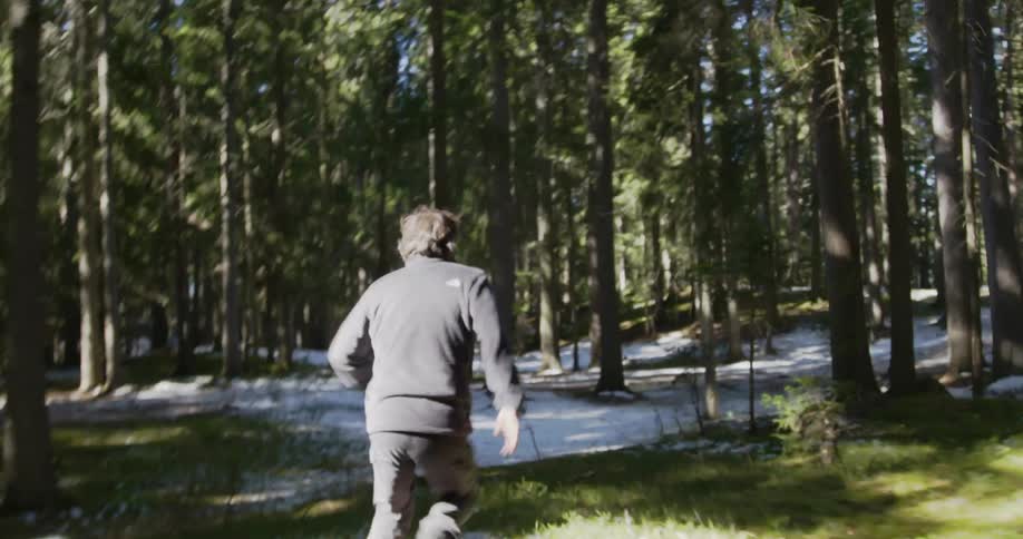 Man running frantically through a forest