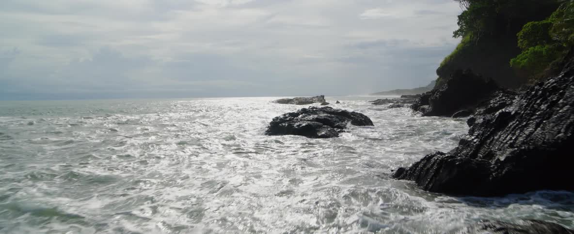 Ocean waves crash into a rocky shoreline