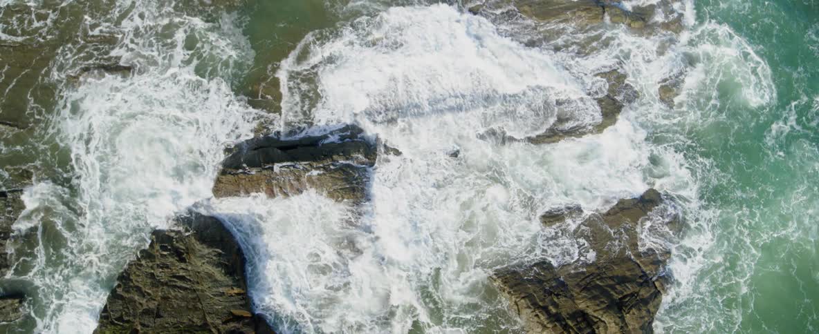 Ocean waves splash and break over rocks