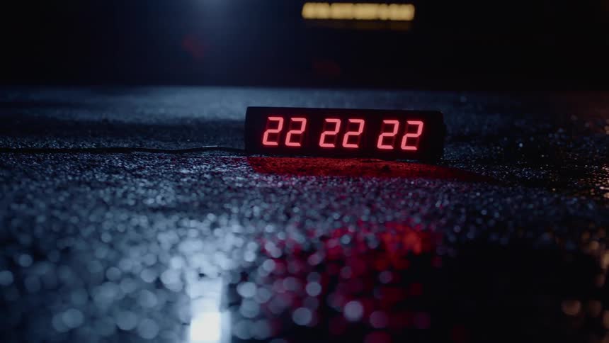 A clock sitting on the ground is showing all twos and the twos are blinking in a sequence