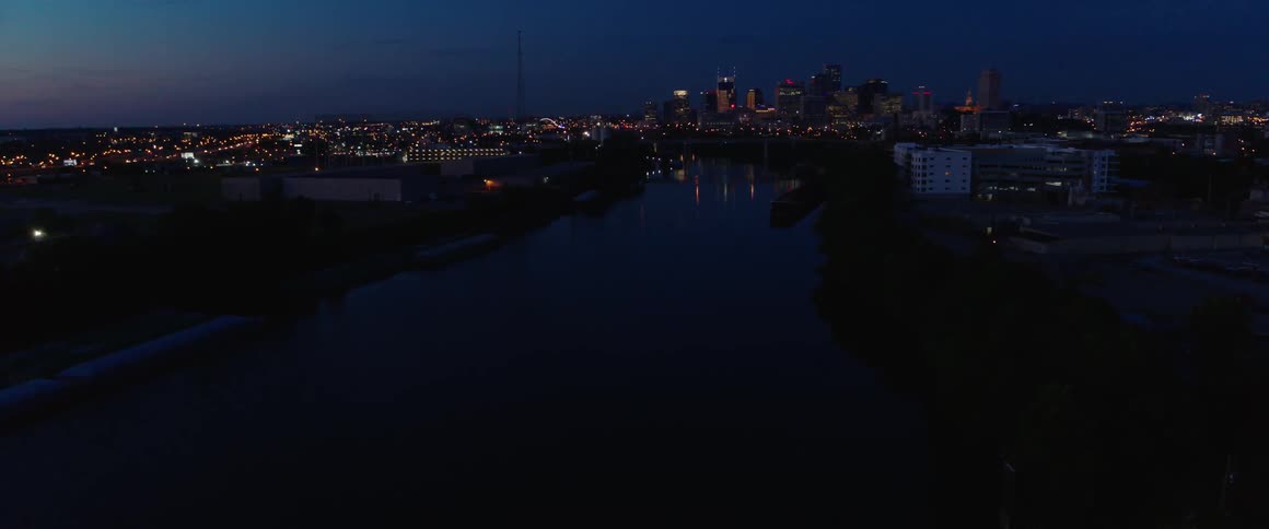 Lights on a tower flash on and off outside a city at dusk