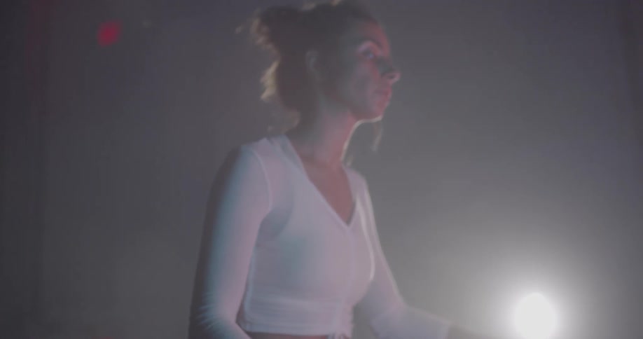 A woman jumps up onto a high padded box and then steps down