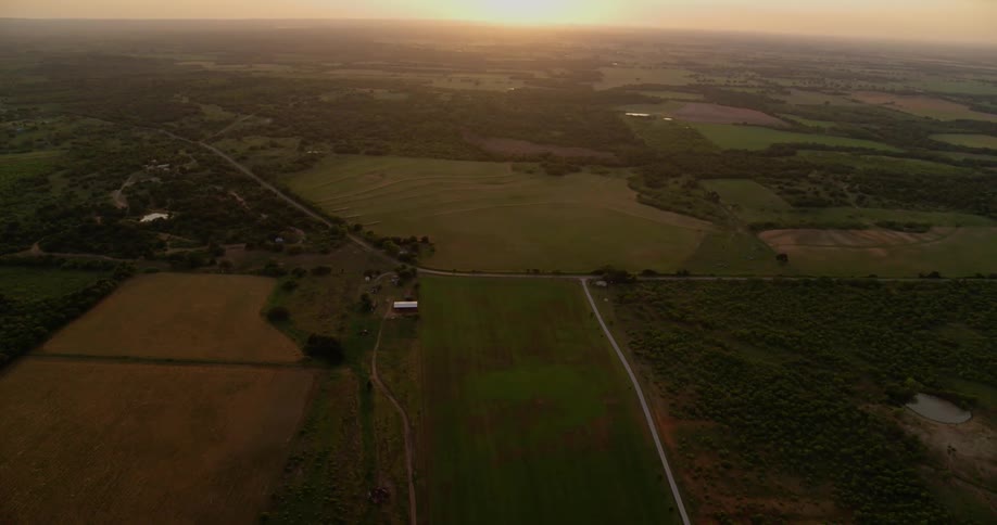 The sun sets over rural fields