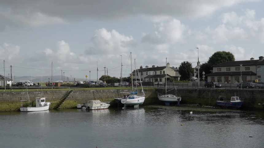 Boats float on a river on a cloudy day