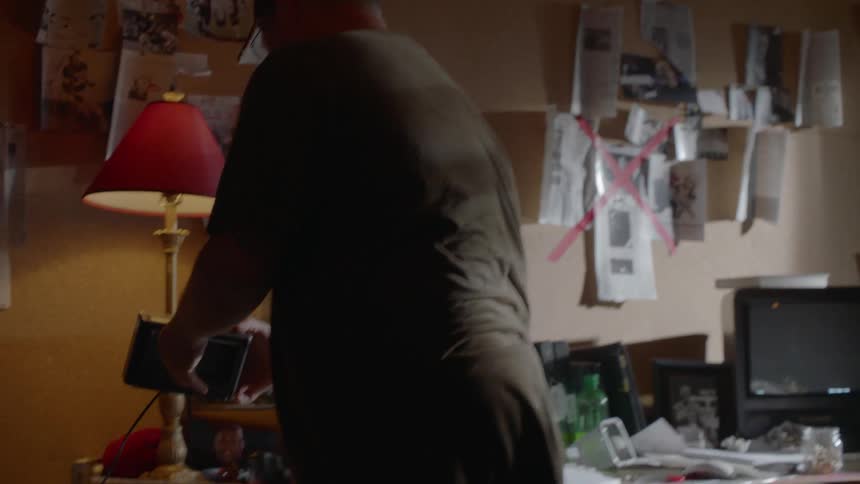 A man is searching through a room and throws something
