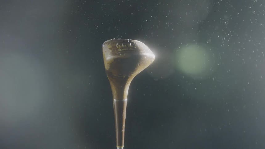 Water droplets fall on a rotating golf club