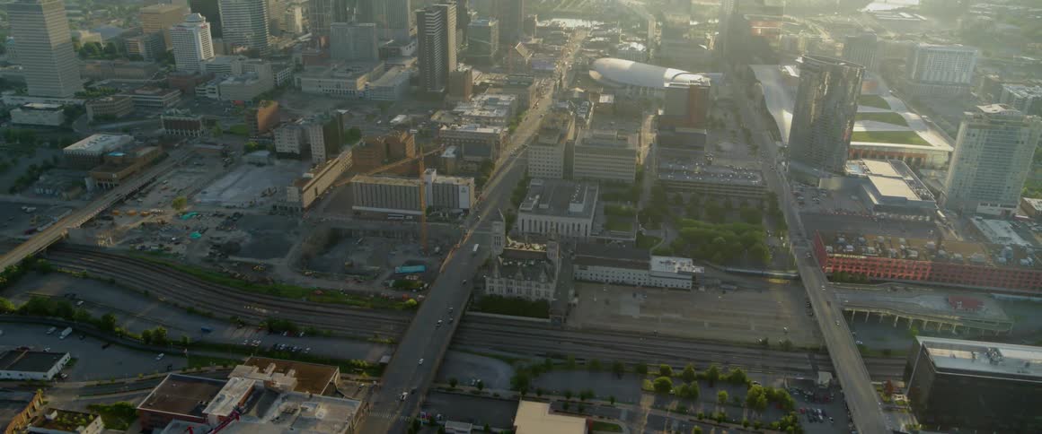 Cars drive on a city street at sunset