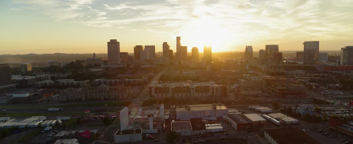 The sun sets behind skyscrapers