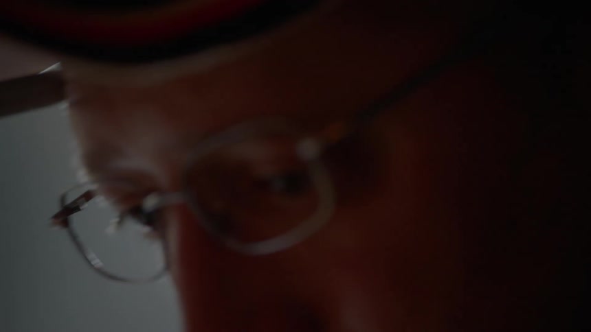 A man is looking down in a dark room