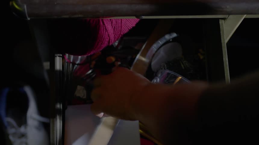 A person opens the drawer and removes a ruler