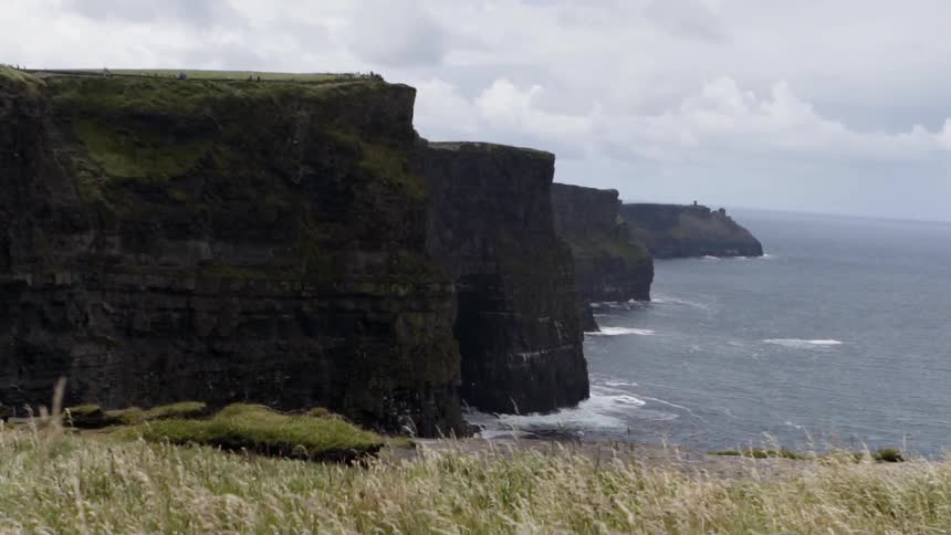 Waves are crashing against a large cliff