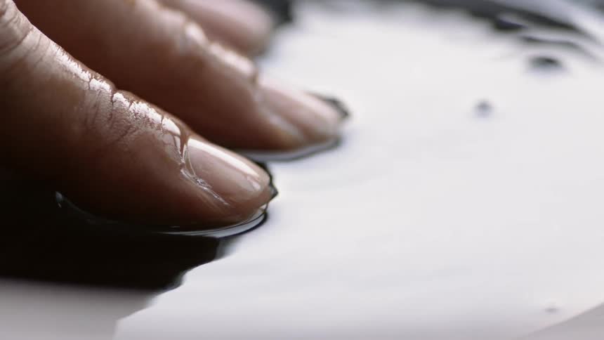 Fingers are submerged in rippling water