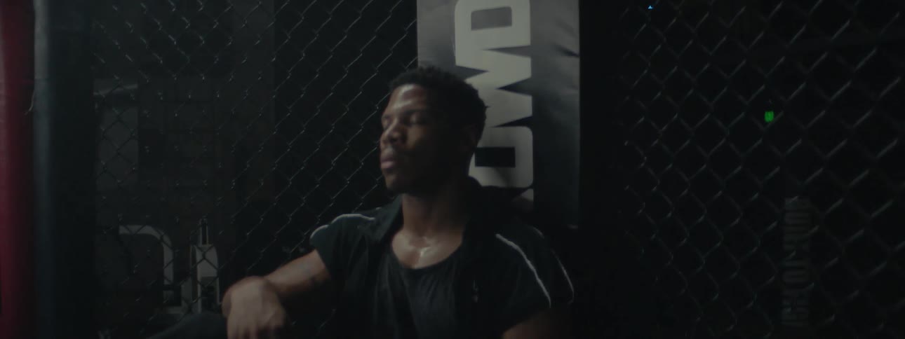 Fighter in an octagon sits and catches his breath