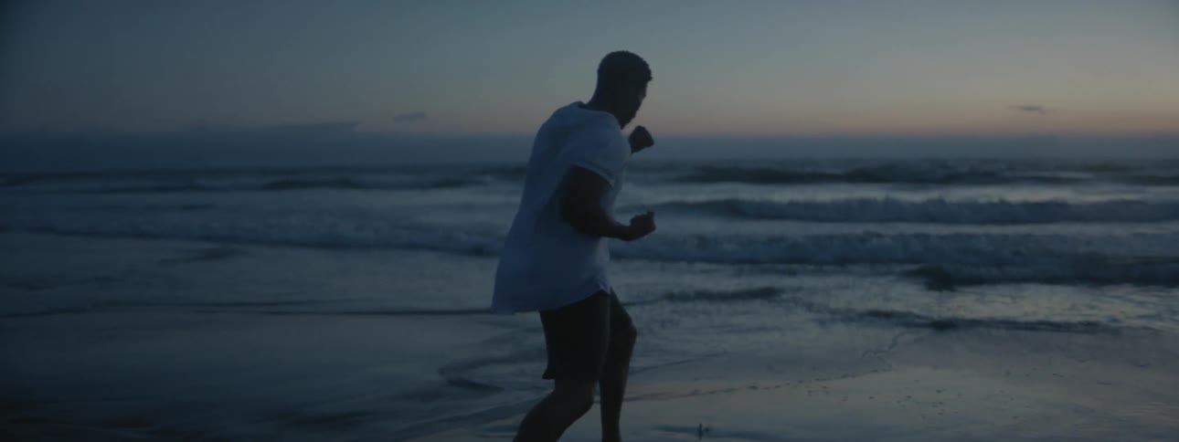 A man punches the air on the beach