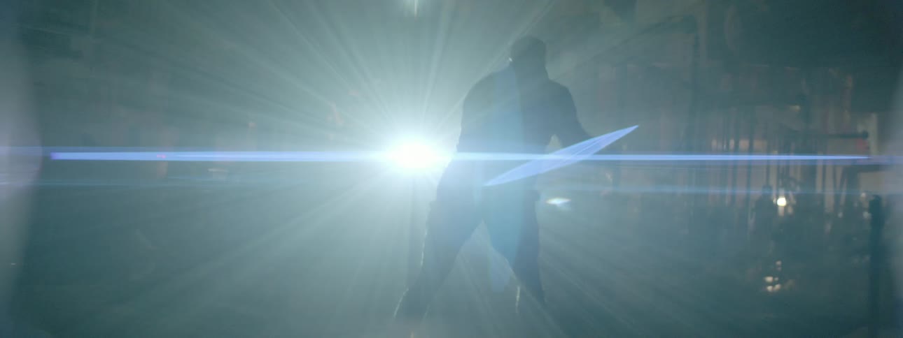 A man practices his mixed martial arts kicks while a lights shines