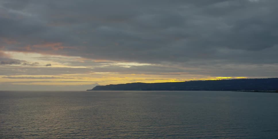 Ocean water ripples beneath a sunset