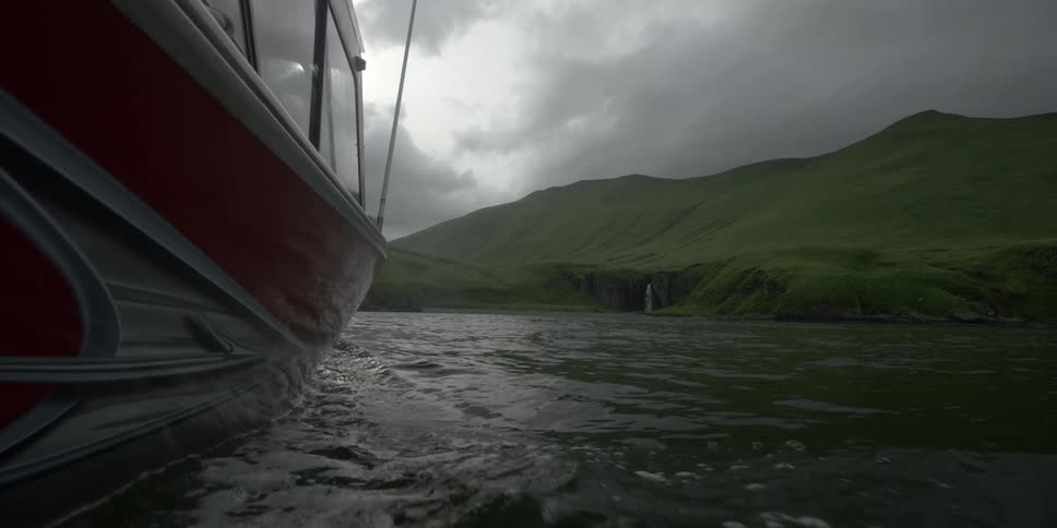 A boat cuts through the water on an overcast day