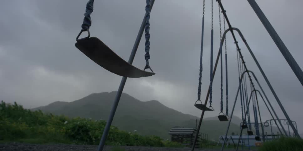Swings sway under overcast skies
