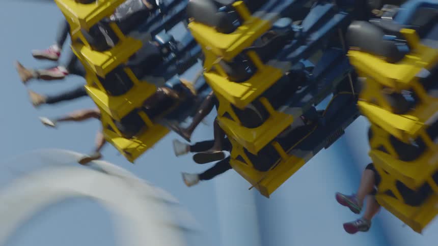 People ride on a rollercoaster in an amusement park