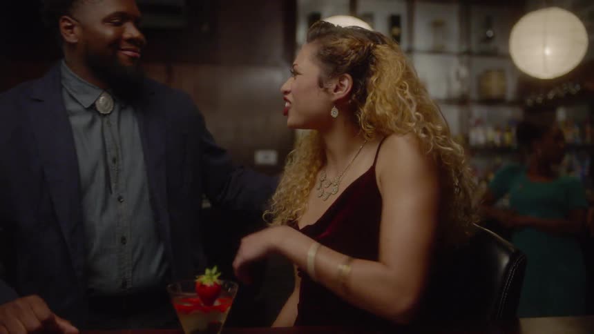 Man brings woman a drink and she greets him