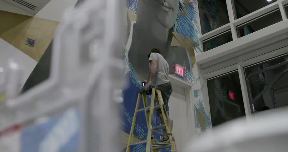 A man is painting an image on the wall