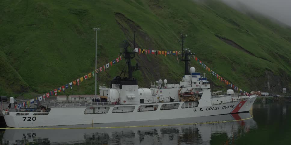 A coast guard ship is docked on the pier