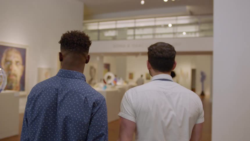 Two men walk through a museum