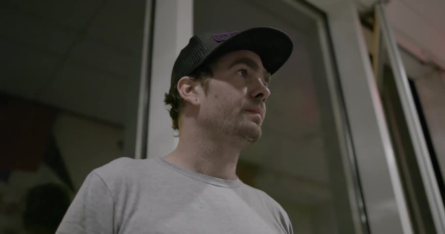 Man stands in front of windows at night