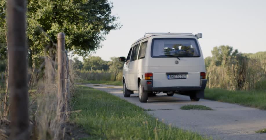 A van is driving down a small road