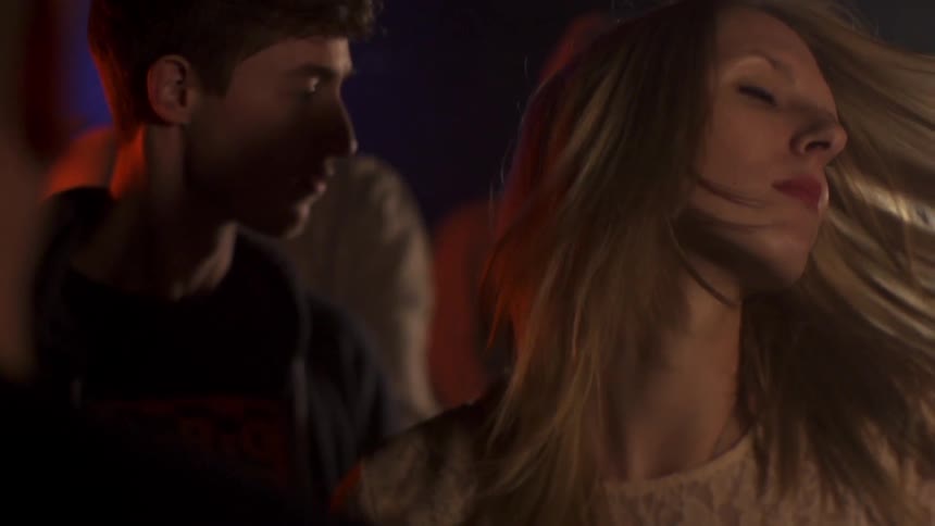 A blond woman dances on the dance floor