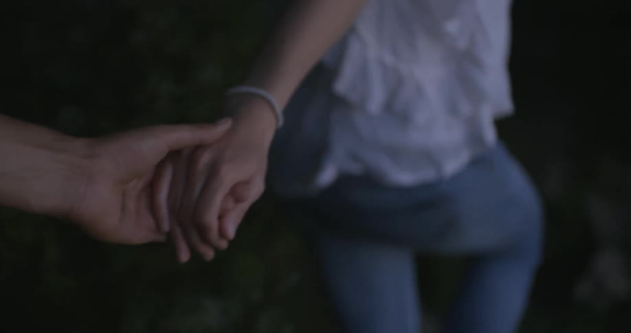 A woman leads a man by the hand