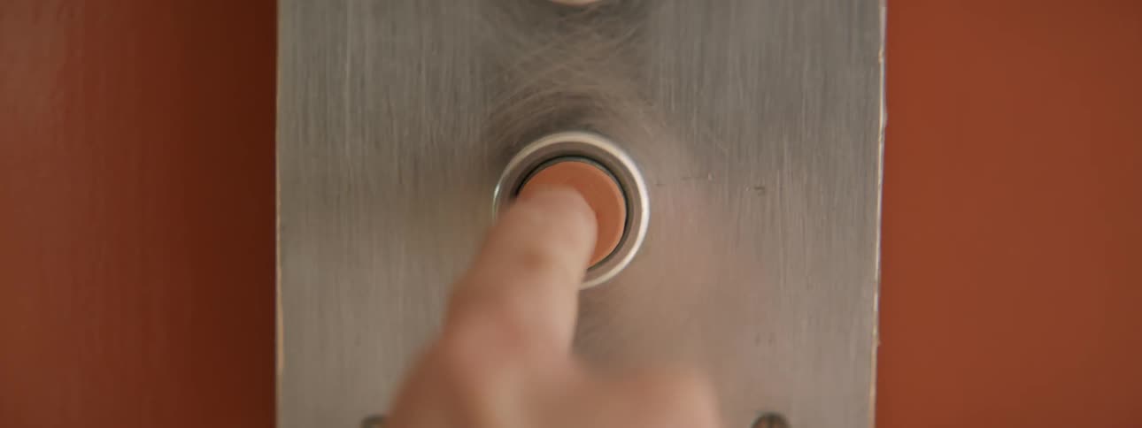 A person presses the orange button