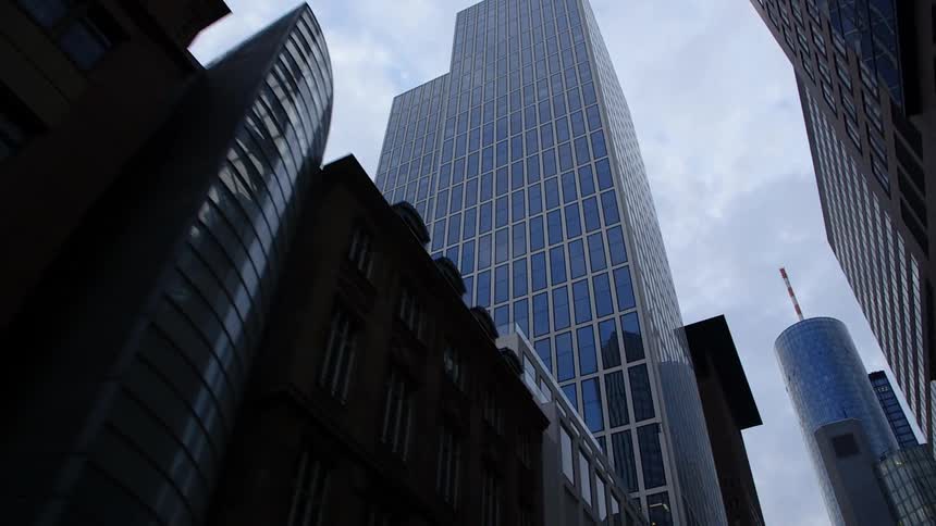 The surrounding buildings reflect off the skyscraper windows