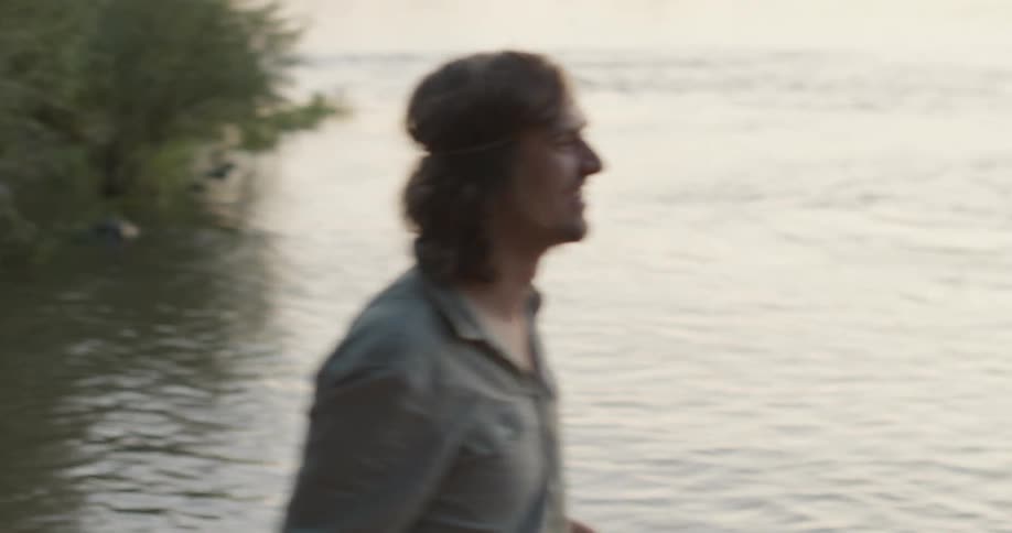 Two men throw a stone around by the water