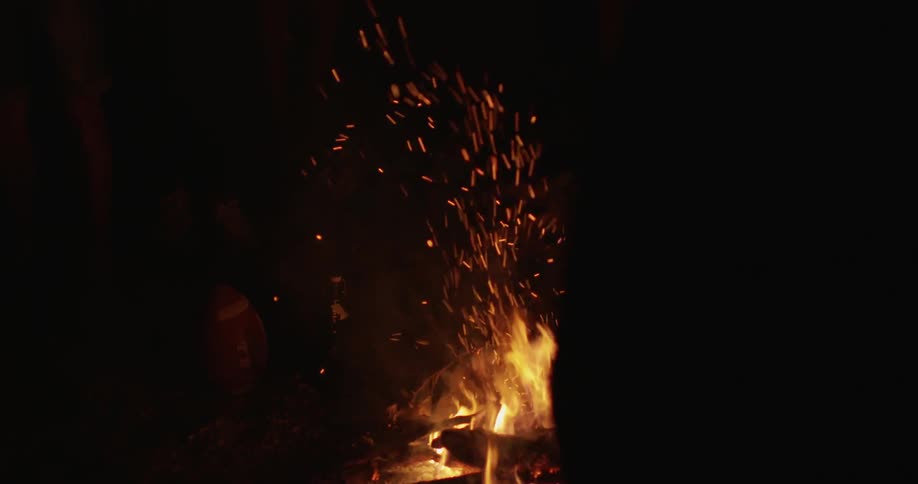 Sparks from a campfire fly into the night air