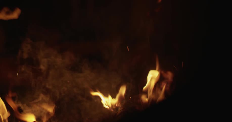 A campfire burns at night