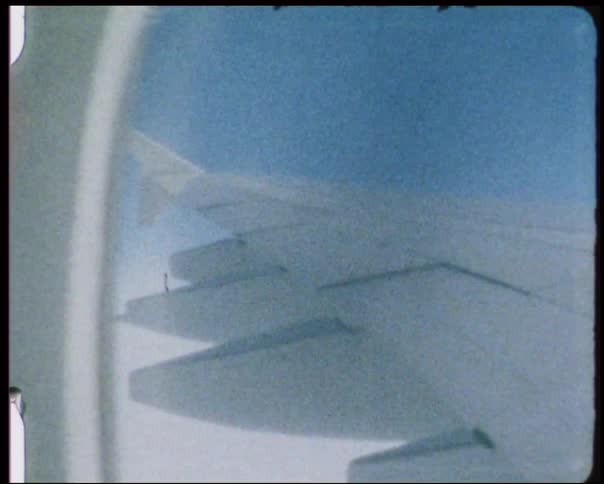 An airplane's wing in flight is visible from the window