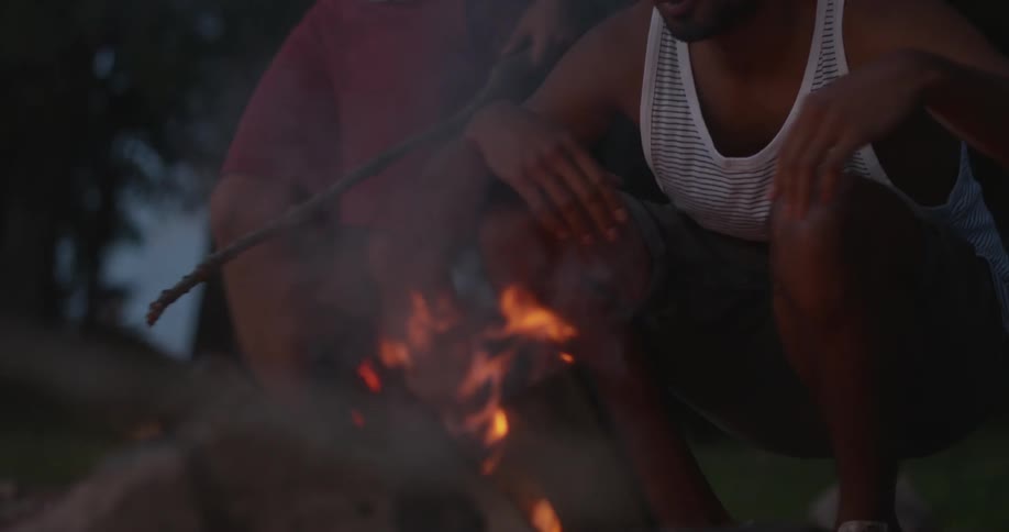A man stacks wood on a fire