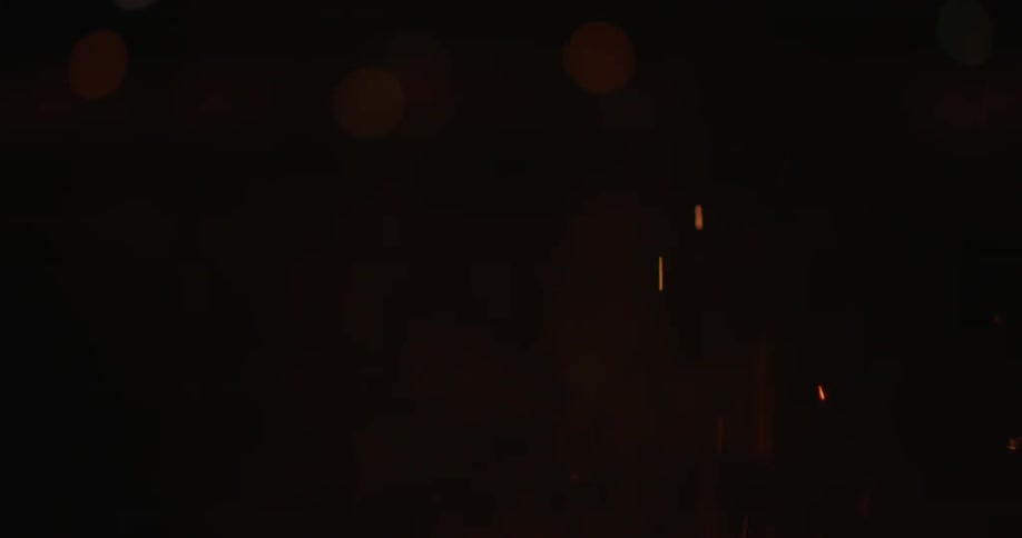 Flames and smoke are rising from a fire at night